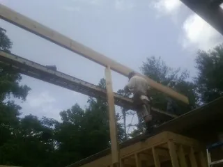 Carpenter setting a ridge beam over a new addition frame — Ice Dam Removal by Roofing Brothers in Lake Lure