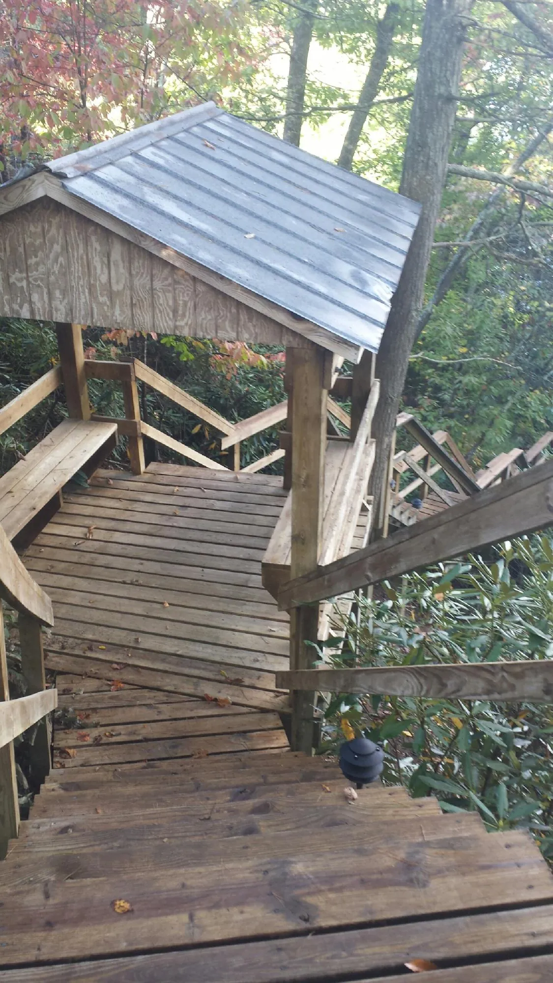 Metal roofed shelter over wooden steps on a wooded walkway — Skylight Repair & Installation work by our crew in Lake Lure