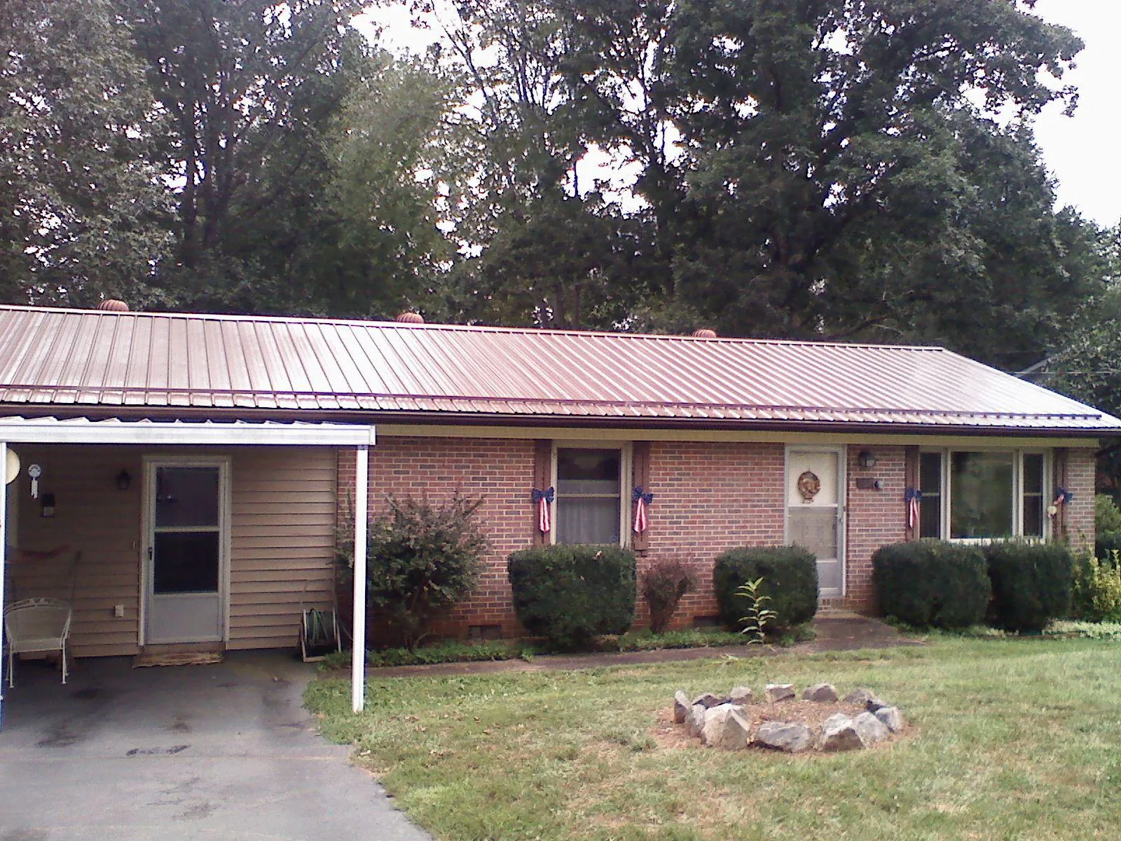 Bronze metal roof and carport on a brick ranch home — Roof Repair work by our crew in Lake Lure