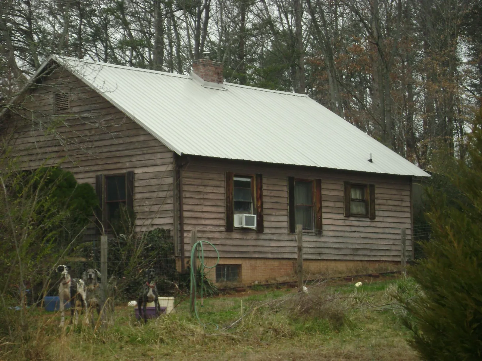 White metal roof on an old wood sided farmhouse, from a Metal Roof Installation job in Lake Lure